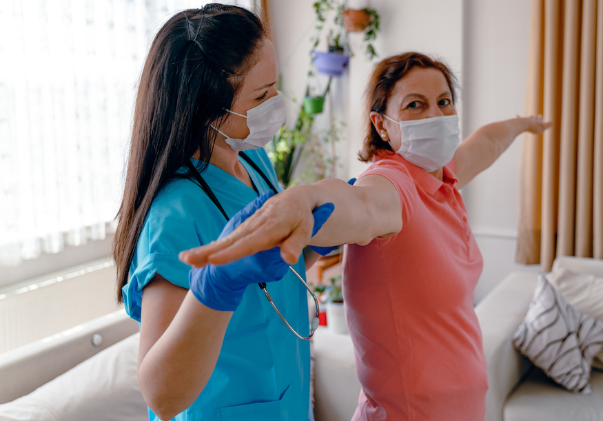 Senior adult woman and home healthcare nurse, physical therapist.