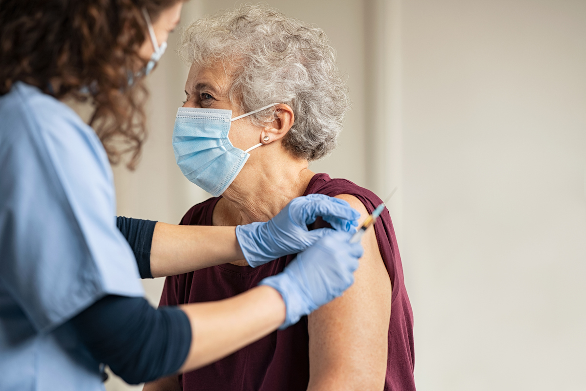 Doctor giving Covid vaccine to senior woman