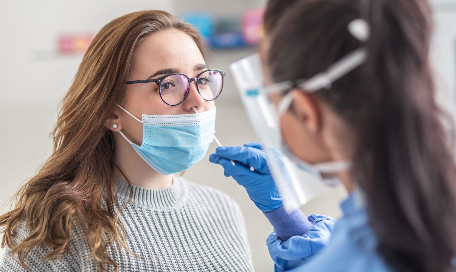 A medical professional performs a COVID test.