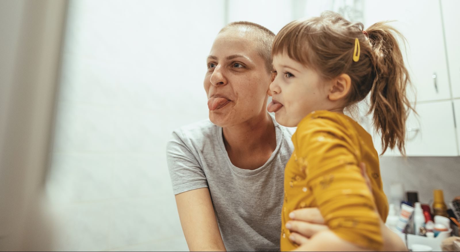 Cancer survivor makes funny faces with her daughter.