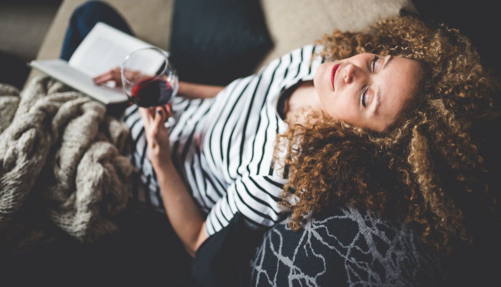 A woman drinks alcohol, which may have positive effects on brain health in small quantities.