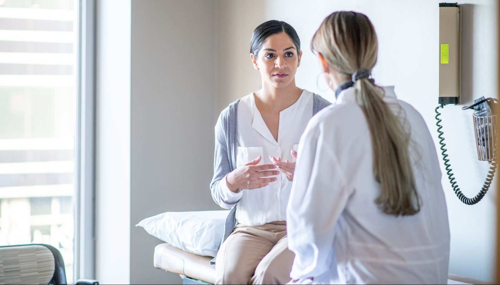 A woman talks to her doctor about cervical cancer, which is on the rise.